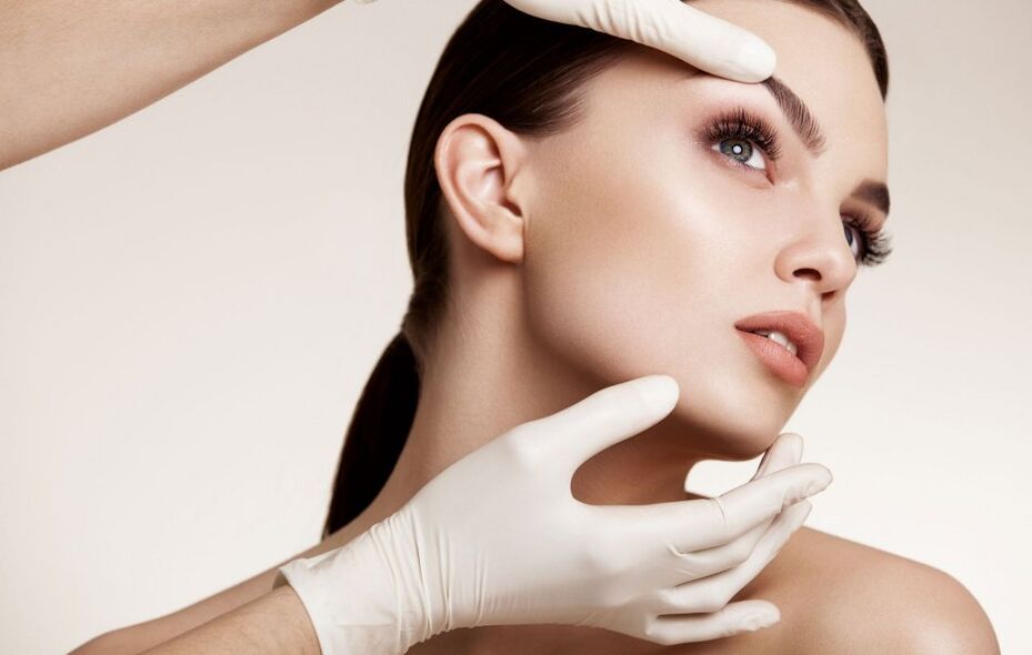 Esteticista que examina la piel facial antes del rejuvenecimiento